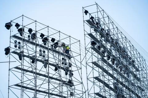 Construction workers assembling large scaffolding and metal rigs for outdoo.. Stock Photos