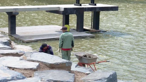 Construction workers assembling modular pier on woodland lake 스톡 동영상 311892688