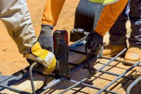 Construction workers assembling rebar framework at building site during works Fotos de archivo