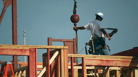 Construction workers attach a load to the hook of the crane at construction site Video stock 34575129