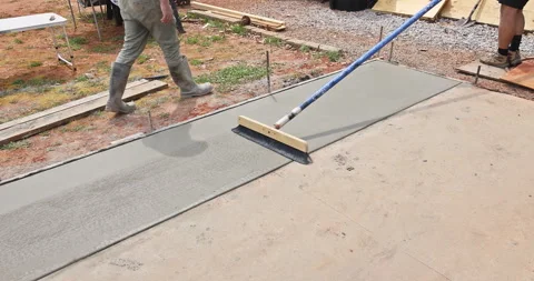 Construction workers brush freshly poured concrete with a broom brushing pattern Stock Footage 273488852
