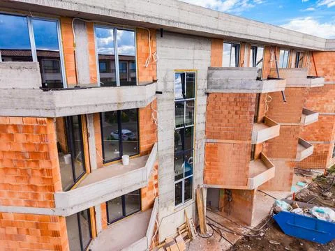 Construction workers build an apartment complex with concrete and bricks in.. Stock Photos