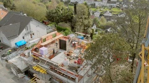 Construction workers build a house shooting from the air Stock Footage 121728440