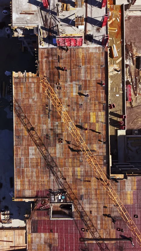 Construction workers build a large structure with cranes at a development site Stock Footage 336573138