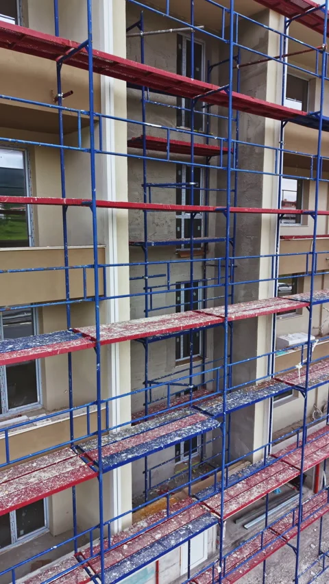 Construction workers build a multi-storey building with scaffolding in an urban Video stock 337907139
