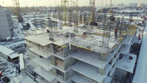 Construction workers build multi-story structure in winter conditions in urban Stock Footage 312028113