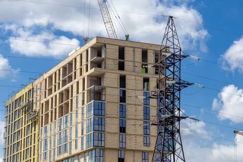 Construction Workers Build New High-Rise Building With Crane and Power Line.. Stock Photos