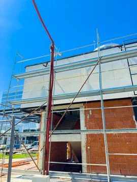 Construction workers build a new structure using scaffolding and other tools. Stock Photos