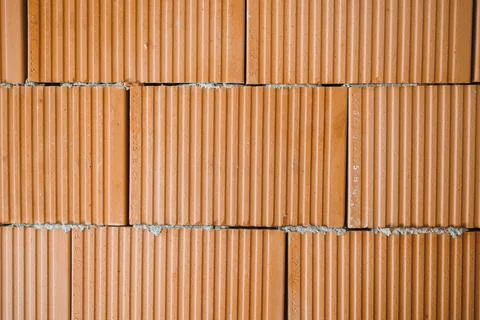 Construction workers build a wall using red bricks in a residential area du.. Stock Photos