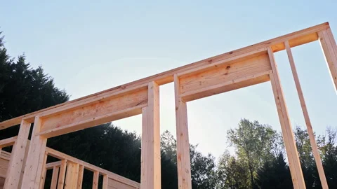 Construction workers build wooden frame in residential area near completed Stock Footage 325344609