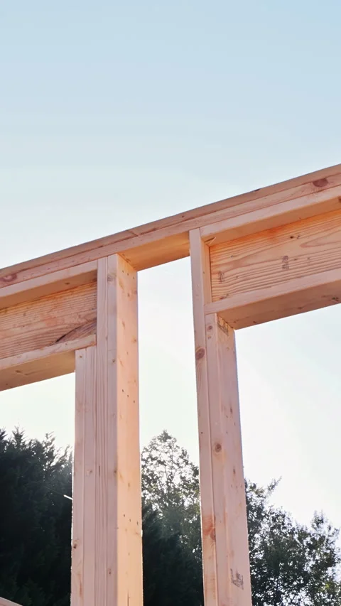 Construction workers build wooden frame in residential area near completed 動画素材 342757516