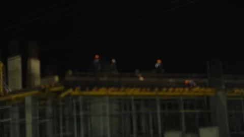 Construction workers building a concrete structure at night with helmets. Stock Footage 342372847