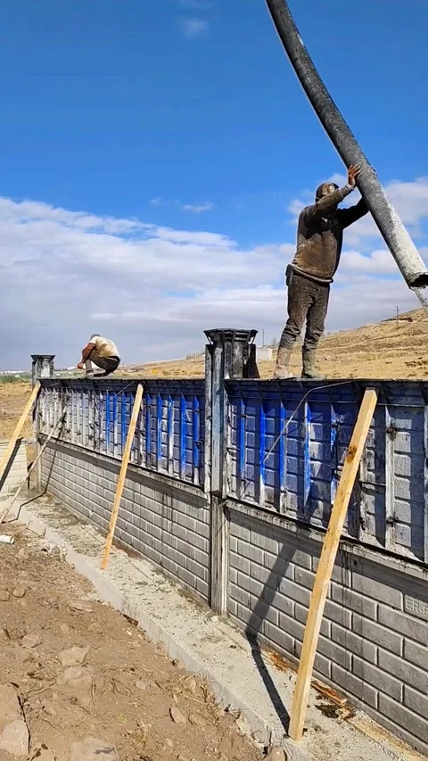 Construction workers building a reinforced concrete wall using a pump truck to Stock-Footage 333240923