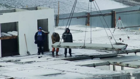 Construction workers on building site carefully lower large precast concrete Stock Footage 339865919