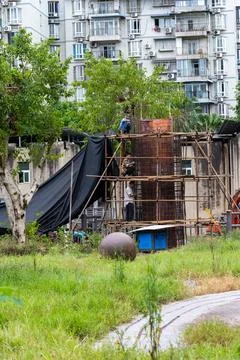 Construction workers building structure with bamboo scaffolding in china Stock Photos