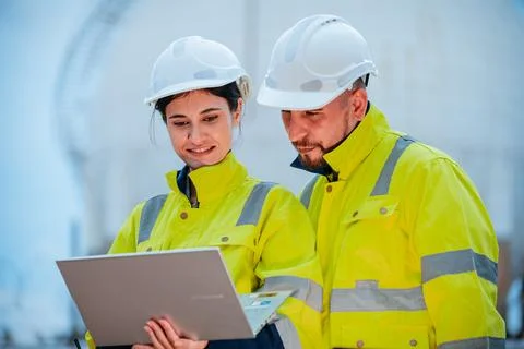 Construction workers collaborate on a project while reviewing plans on a la.. Foto stock