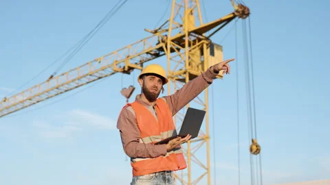 Construction workers collaborate on site with technology in slow motion Stock Footage 303229625
