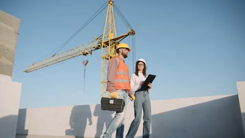 Construction workers collaborate in slow motion on a building site Stock Footage 303228926