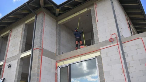 Construction Workers Complete Exterior Painting on a New Building Project in a Stock Footage 308530714