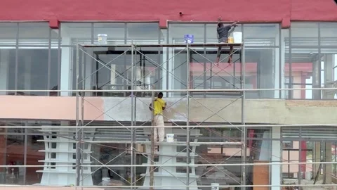 Construction workers on construction site painting building Stock Footage 249911677