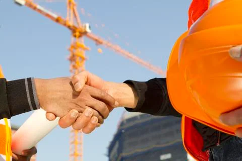 Construction workers with crane in background Stock Photos