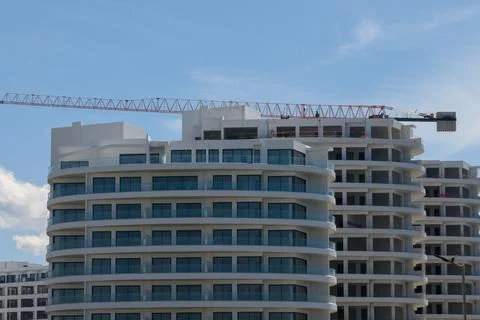 Construction workers diligently complete a modern high-rise project against.. Fotos de archivo