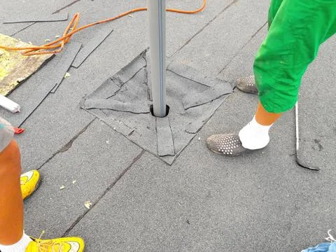 Construction workers diligently working together to repair a roof, ensuring 写真素材