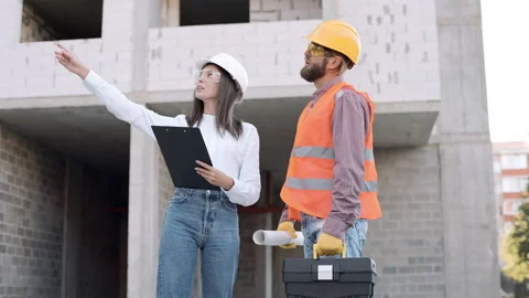 Construction workers discuss project details at urban building site Video stock 311304154