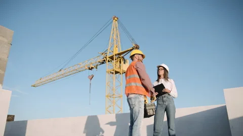 Construction workers discuss project plans at a busy construction site Stock Footage 286047097
