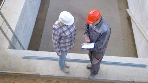 Construction workers discussing plans at building site 库存影片 315649652