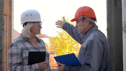 Construction workers discussing plans to work on building site Video stock 315470913