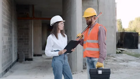 Construction workers discussing project details on-site at a building Stock-Footage 286044559