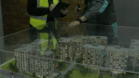 Construction workers discussing project plans with a city skyline Stock Footage 323167756