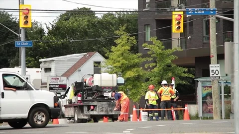 Construction workers dressed in orange with x on their shirts tops with a police Stock Footage 248715177