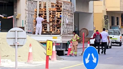 Construction workers in Dubai loading wooden pallets into a truck. 스톡 동영상 311891401