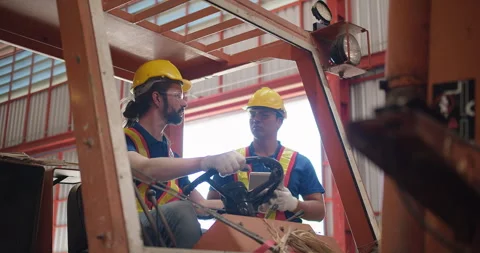 Construction workers engineers in yellow hard hats and safety vests are discussi Stock Footage 272295899