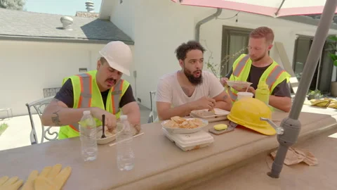 Construction workers enjoy lunch outdoors, surrounded by nature, fostering Stock Footage 305818006