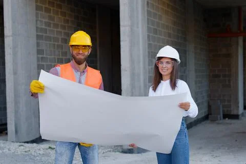 Construction workers examining blueprint on site Stock Photos