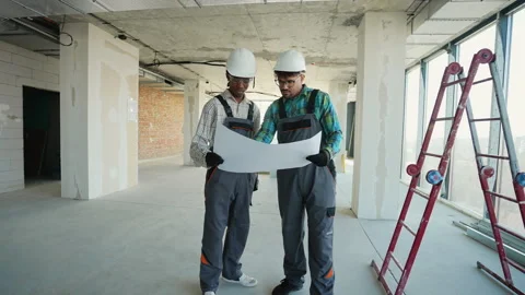 Construction workers examining blueprint in unfinished building Video stock 312837646