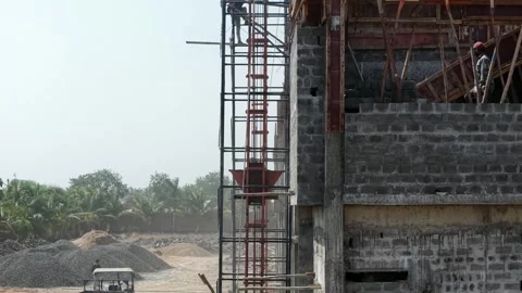 Construction Workers Gathering Material at Industrial Building Site with Stock Footage 344230192