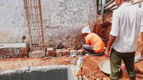 Construction workers with granite stone wall, red soil and rusted column at Stock Footage 334187895