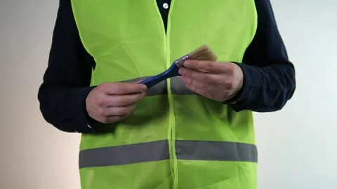 A construction workers hands, clad in a reflective safety vest, carefully feel Stock Footage 318517427