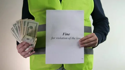 A construction workers hands present money and a penalty notice, symbolizing Stock Footage 315744441