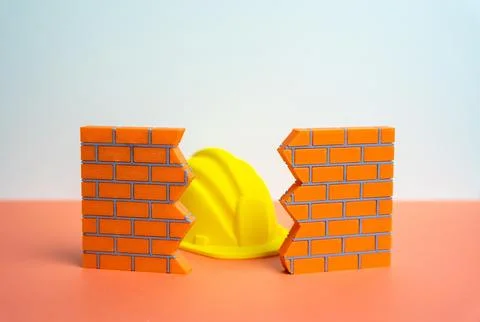A construction worker's hard hat in a wall crack. Architectural repair and de Stock Photos