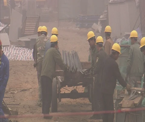 Construction workers in hard hats load and push cart full of iron bars Stock Footage 86744209