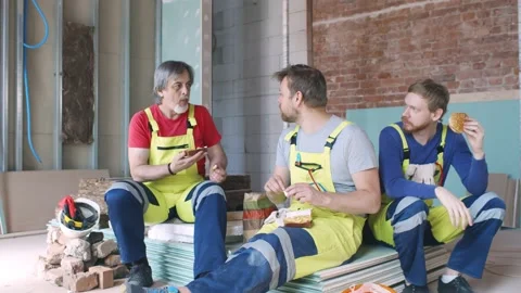 Construction workers having lunch break sitting on site Stock Footage 133640298