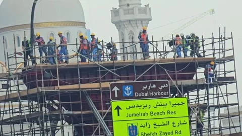 Construction workers on high scaffolding perform building and renovation Stock Footage 320797285