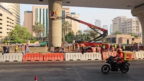 Construction workers in high-visibility vests and helmets working on an urban Stock Footage 339703959