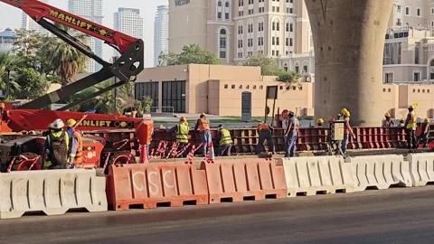 Construction workers in high-visibility vests and helmets working on an urban Stock Footage 339703969