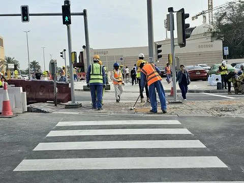 Construction workers in high-visibility vests are busy on a city street Fotos Stock